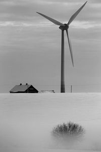 Windmill on land against sky