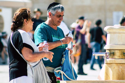 Side view of two people standing outdoors