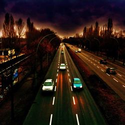 Road passing through illuminated city at night