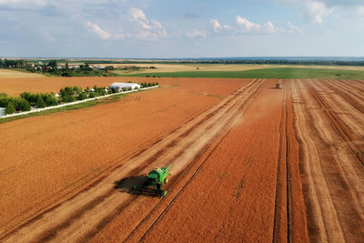 Tractor on agricultural field against sky