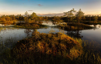 Scenic view of lake against sky at sunset