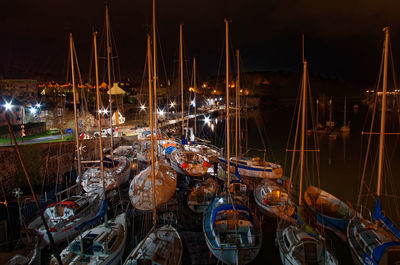 Boats moored in illuminated at night