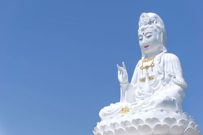 Low angle view of statue against blue sky