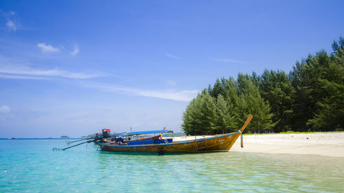 Boat moored in sea against sky