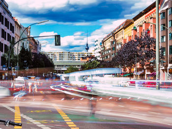 View of city street against cloudy sky