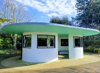 Built structure by trees against blue sky