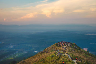 Aerial view of people on mountain peak against sky