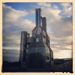 Low angle view of buildings against cloudy sky