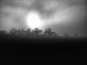 Silhouette trees on field against sky