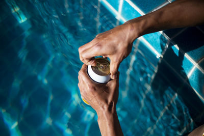 Selective focus white beer can in hand. man is soaking in the pool with an open beer can relax 