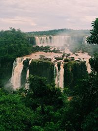 Scenic view of waterfall against sky