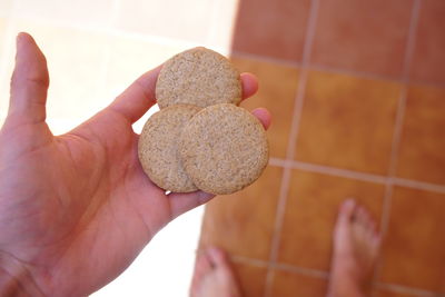 High angle view of person hand holding tiled floor