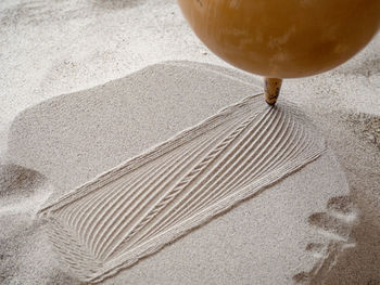 Close-up of coffee cup on sand