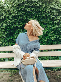 Young woman sitting on bench in park