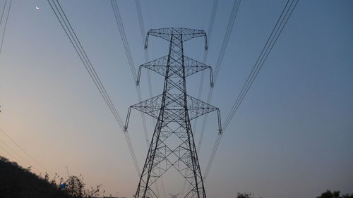 Low angle view of electricity pylon against clear sky