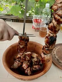 Close-up of hand holding food served on table