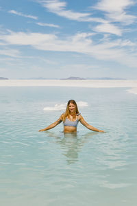 Young woman in bathing suit exploring the bonneville salt flats.