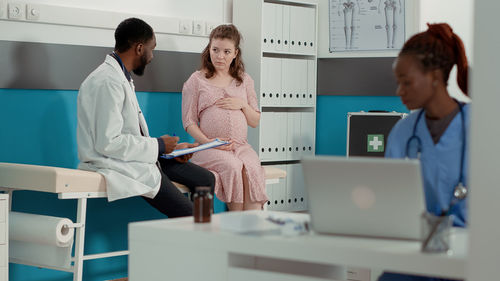 Doctor discussing with pregnant woman at clinic