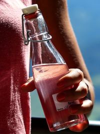 Cropped image of woman holding syrup bottle