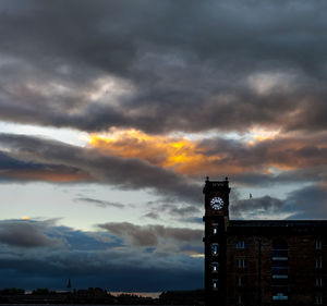 Low angle view of clock tower against dramatic sky
