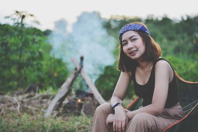 Portrait of young woman sitting on field