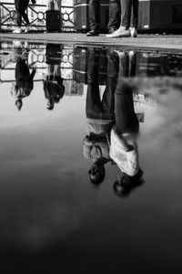 Low section of people walking on puddle