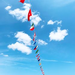 Low angle view of flags hanging against sky