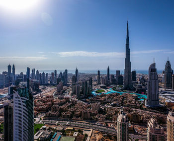 Aerial view of cityscape against blue sky