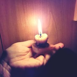 Close-up of human hand holding candle