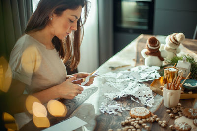 Young woman sitting on table at home