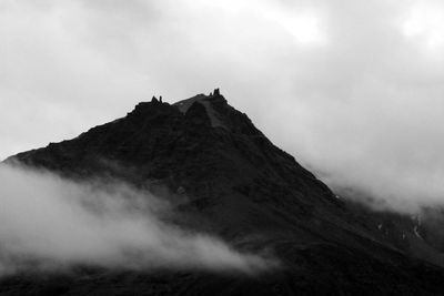 Low angle view of mountain against cloudy sky