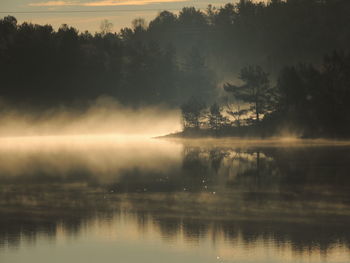 Scenic view of lake against sky at sunset