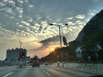 Cars on road in city against sky