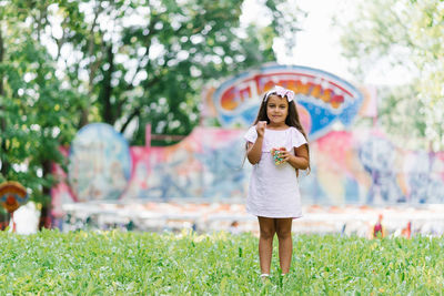 Child girl eats popcorn at an amusement park on summer vacation.
