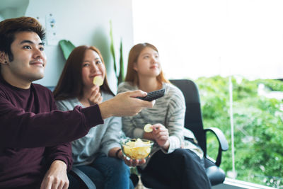 Friends eating potato chips while watching tv together