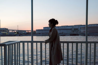 Side view of woman looking at sea against sky