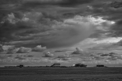 Scenic view of beach against cloudy sky