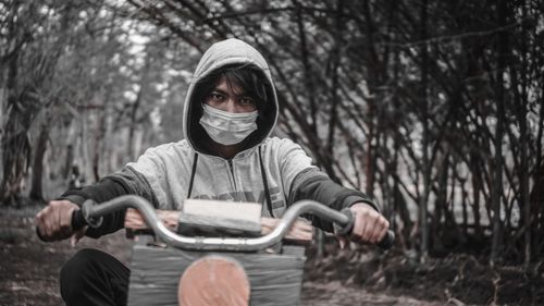 Portrait of man wearing mask riding bicycle on road