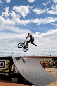 Man riding bicycle against sky