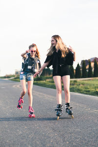 Friends roller skating on road