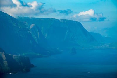 Scenic view of sea and mountains against sky