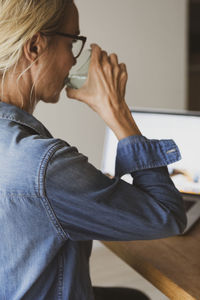 Woman at laptop drinking