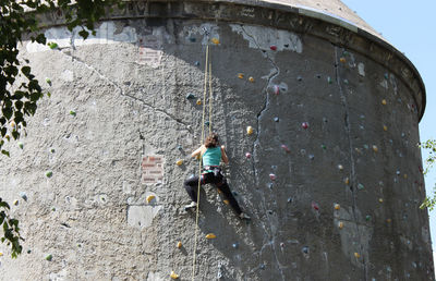 Low angle view of man climbing on rock