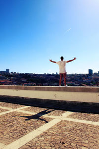 Full length of woman standing against clear blue sky