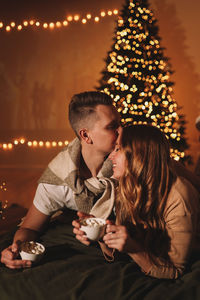 A romantic couple in love celebrates christmas holidays and new year in a cozy house at night