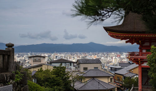 View of cityscape against cloudy sky