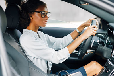 Side view of woman sitting in car