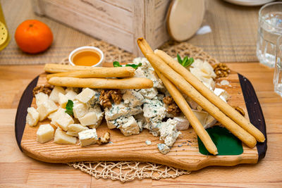 Cheese platter with gorgonzola, blue cheese, walnuts and honey. few bread sticks.