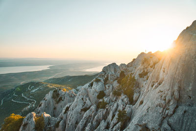 Scenic view of sea and mountains against clear sky