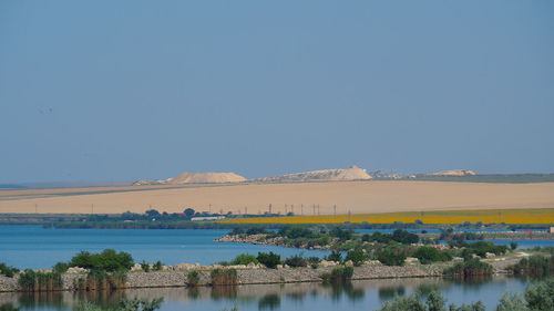 Scenic view of lake against clear blue sky